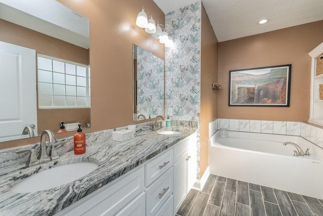 bathroom featuring double vanity, a sink, a garden tub, and wood finished floors