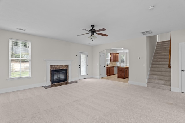 1606 Cedar Hill Dr, Grovetown, GA 30813 - unfurnished living room featuring light carpet, arched walkways, a high end fireplace, and stairway