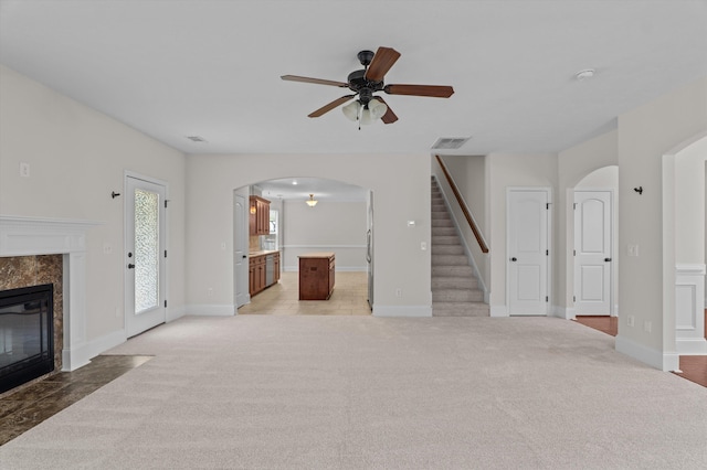 1606 Cedar Hill Dr, Grovetown, GA 30813 - unfurnished living room with arched walkways, ceiling fan, stairway, a high end fireplace, and light colored carpet