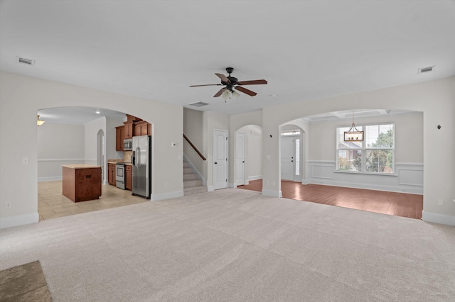 1606 Cedar Hill Dr, Grovetown, GA 30813 - unfurnished living room with light carpet, arched walkways, a ceiling fan, and stairway