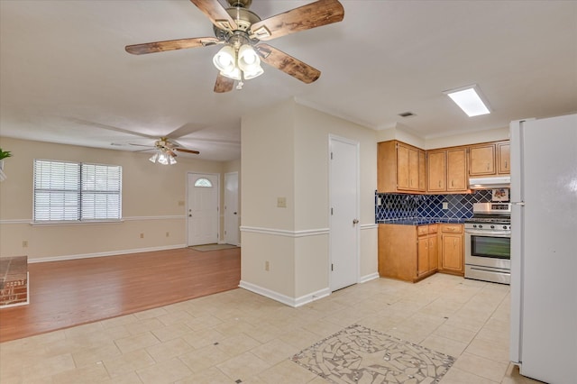 4520 Caliburn Way, Grovetown, GA 30813 - kitchen with freestanding refrigerator, stainless steel range with gas stovetop, under cabinet range hood, ceiling fan, and tasteful backsplash