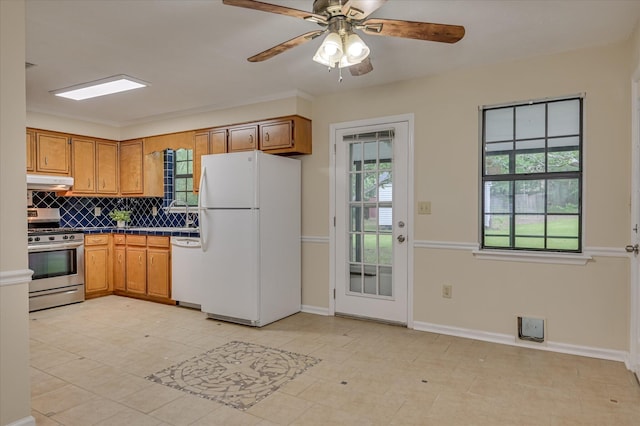 4520 Caliburn Way, Grovetown, GA 30813 - kitchen with white appliances, backsplash, dark countertops, brown cabinetry, and under cabinet range hood