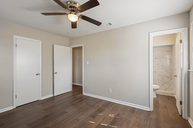 unfurnished bedroom featuring dark wood-style floors, connected bathroom, visible vents, and baseboards