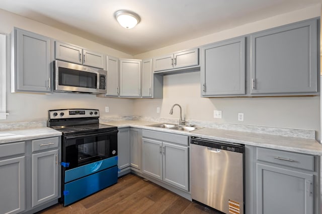 kitchen featuring a sink, gray cabinets, stainless steel appliances, and light countertops