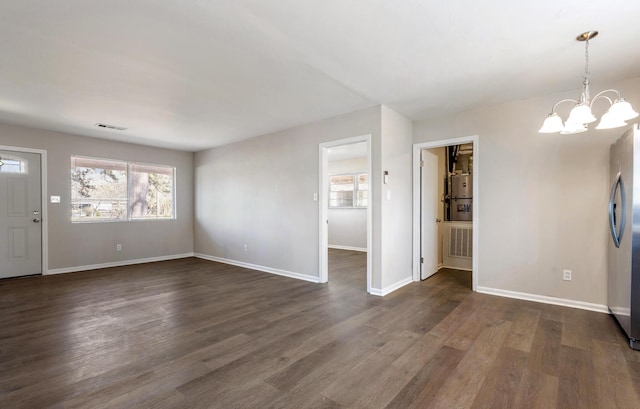 foyer featuring dark wood-type flooring, visible vents, baseboards, and an inviting chandelier