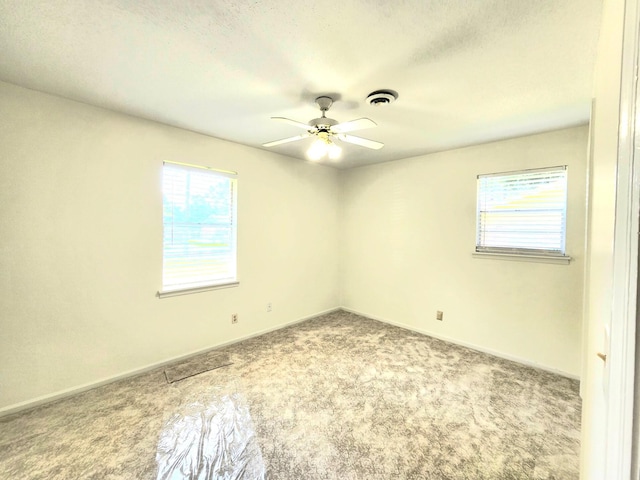 spare room featuring carpet flooring, ceiling fan, and a textured ceiling