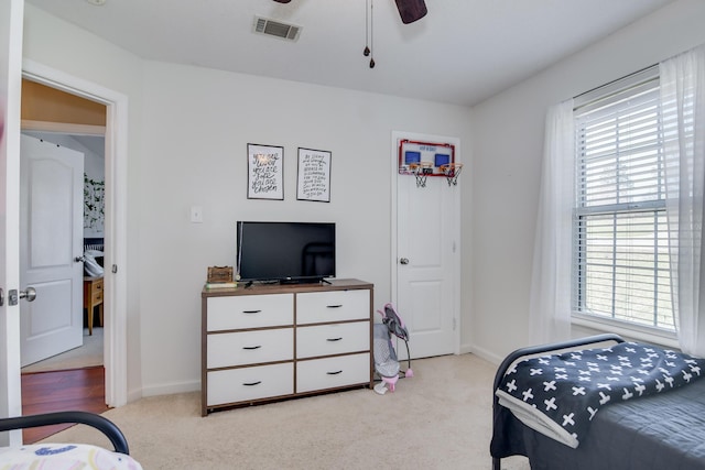 bedroom with baseboards, ceiling fan, visible vents, and light colored carpet