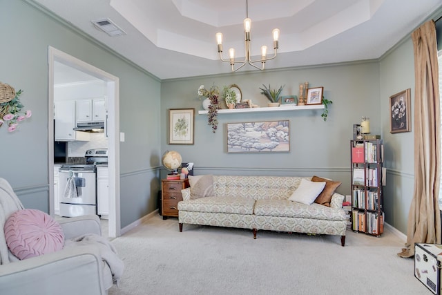 living room featuring a tray ceiling, visible vents, light carpet, and an inviting chandelier