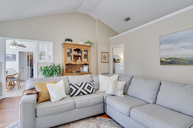 living room featuring vaulted ceiling, ceiling fan, wood finished floors, and visible vents