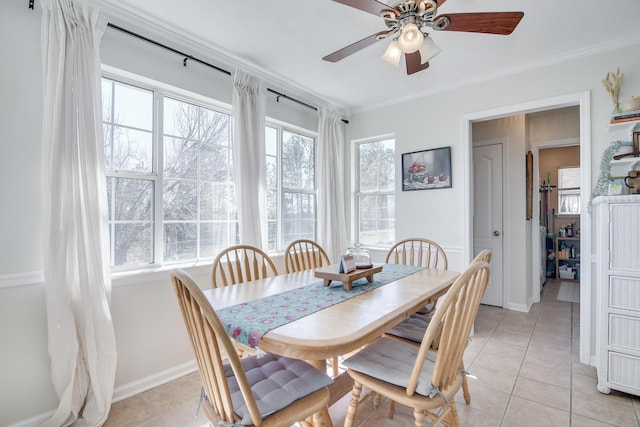 dining area with light tile patterned floors, ceiling fan, baseboards, and crown molding