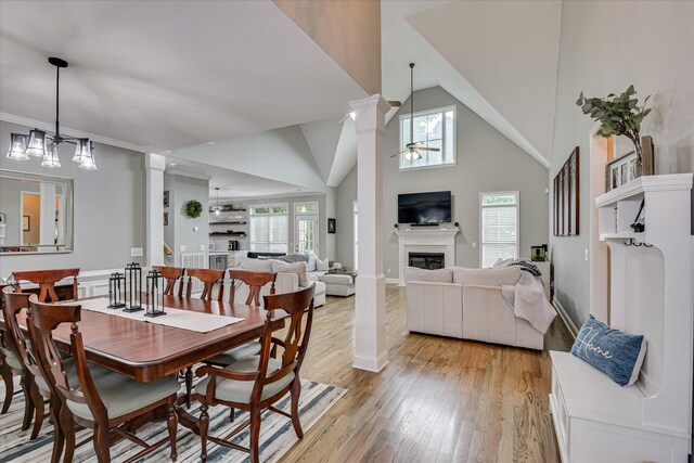 1176 Sumter Landing Cir, Evans, GA 30809 - dining space with a ceiling fan, a glass covered fireplace, light wood finished floors, ornate columns, and high vaulted ceiling