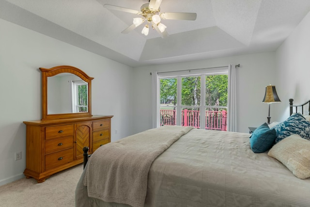 bedroom featuring ceiling fan, light carpet, baseboards, and a raised ceiling