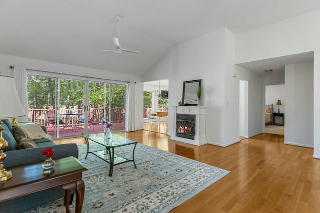 living area featuring baseboards, wood finished floors, high vaulted ceiling, and ceiling fan