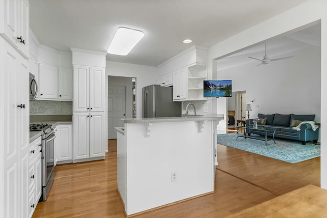 kitchen with open shelves, white cabinets, and appliances with stainless steel finishes