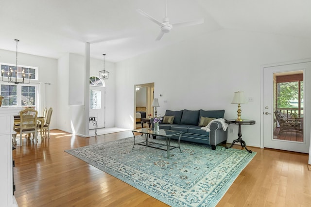 living area featuring plenty of natural light, light wood-type flooring, and ceiling fan with notable chandelier