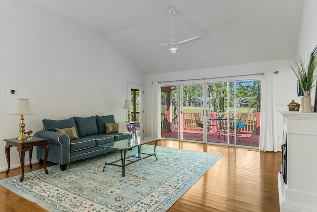 living room with a fireplace, wood finished floors, a ceiling fan, and high vaulted ceiling