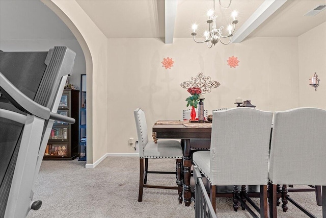 dining room with beam ceiling, light colored carpet, and a notable chandelier