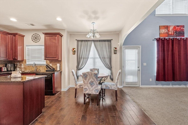 dining room featuring dark hardwood / wood-style floors, sink, and a chandelier