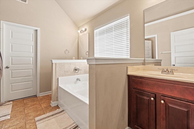 bathroom featuring tile patterned flooring, vanity, a bathtub, and lofted ceiling