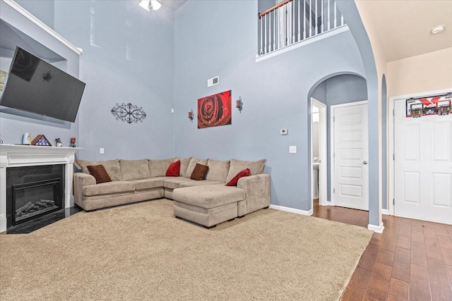 living room with wood-type flooring and a high ceiling