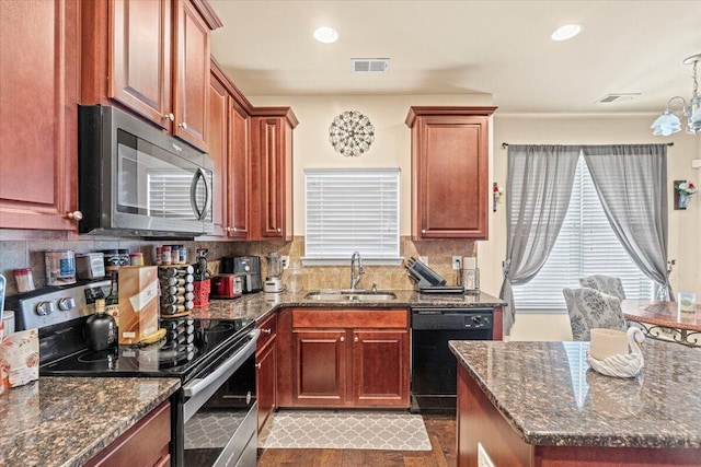 kitchen featuring decorative backsplash, stainless steel appliances, dark stone counters, and sink