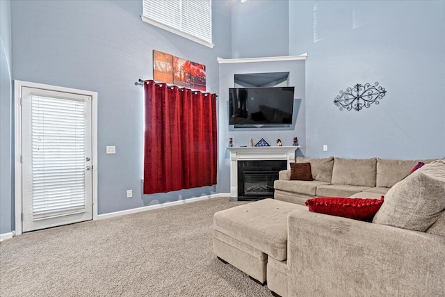 carpeted living room with a towering ceiling