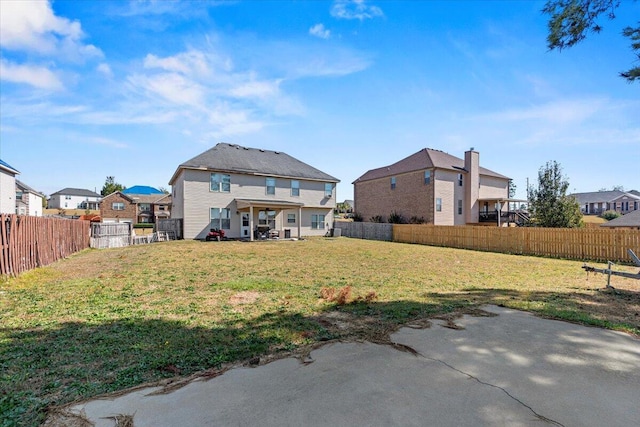 back of house with a patio and a lawn