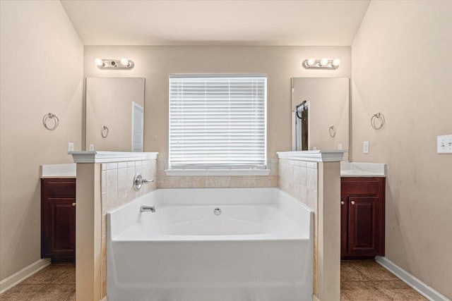 bathroom with tile patterned flooring, vanity, and a tub to relax in