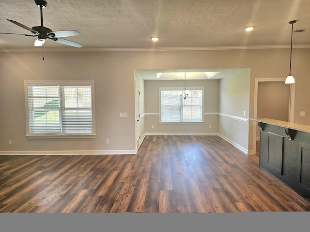 unfurnished room featuring dark wood-style flooring, a textured ceiling, and baseboards