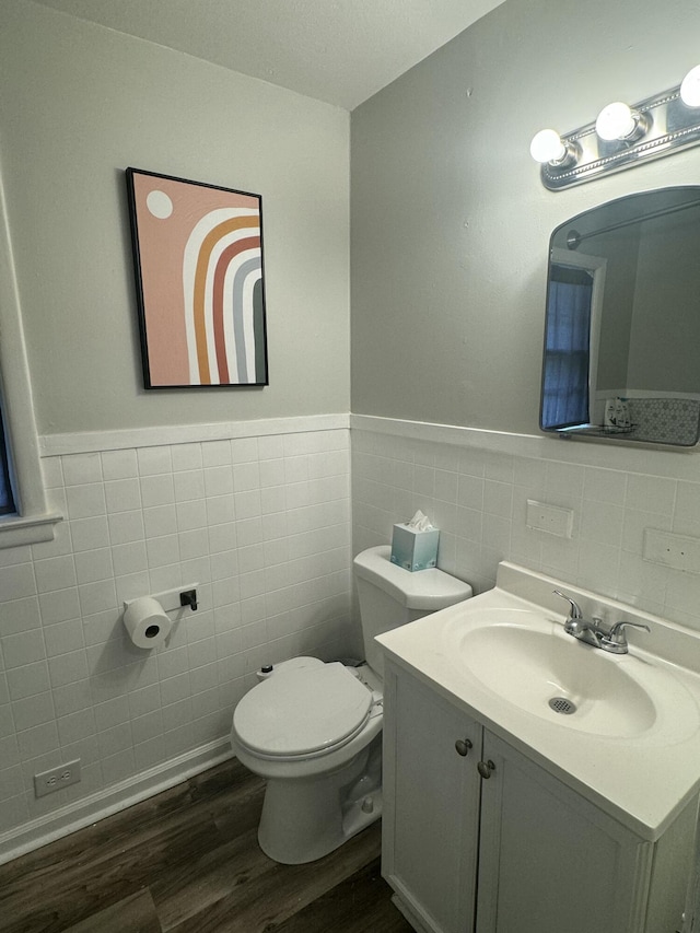 bathroom with vanity, wood-type flooring, tile walls, and toilet