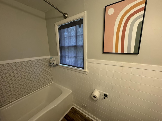 bathroom featuring tile walls and a bathing tub