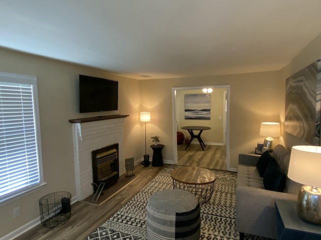 living room with a brick fireplace and hardwood / wood-style flooring