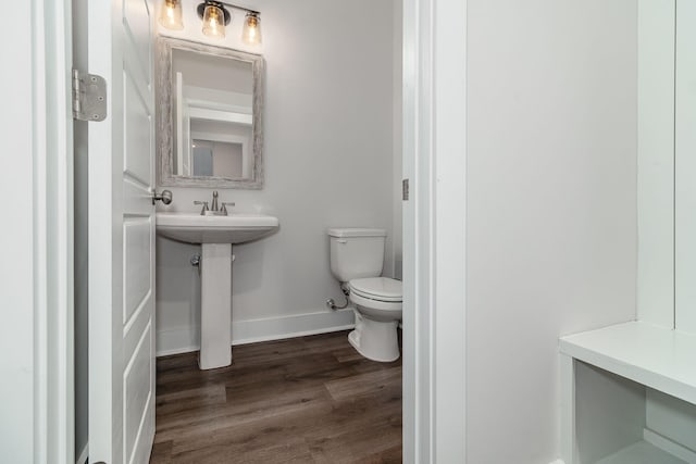 bathroom with toilet, baseboards, and wood finished floors