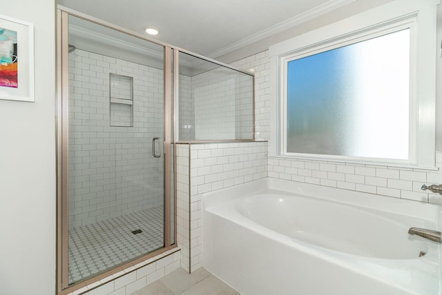 bathroom with a bath, a stall shower, tile patterned flooring, and crown molding