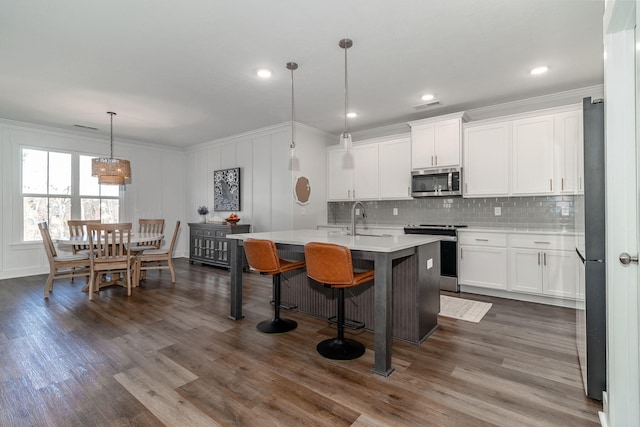 kitchen featuring a sink, visible vents, light countertops, appliances with stainless steel finishes, and crown molding