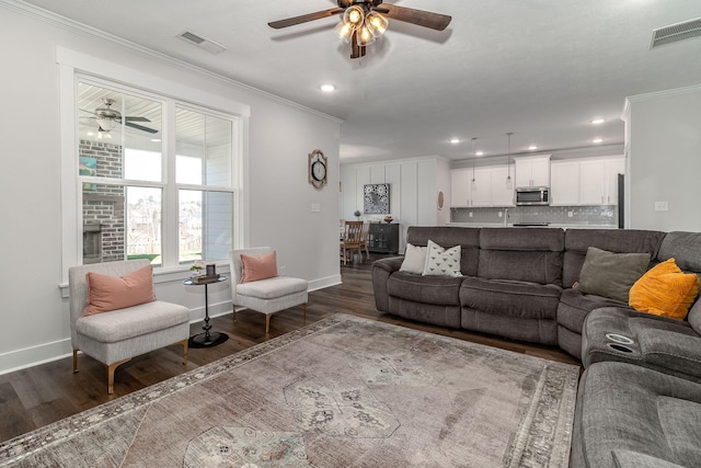 living area with dark wood-style floors, visible vents, and crown molding