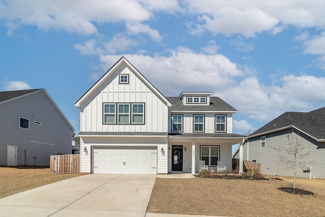 view of front of property featuring an attached garage, covered porch, fence, driveway, and board and batten siding