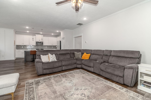 living area featuring visible vents, a ceiling fan, dark wood-style floors, crown molding, and recessed lighting