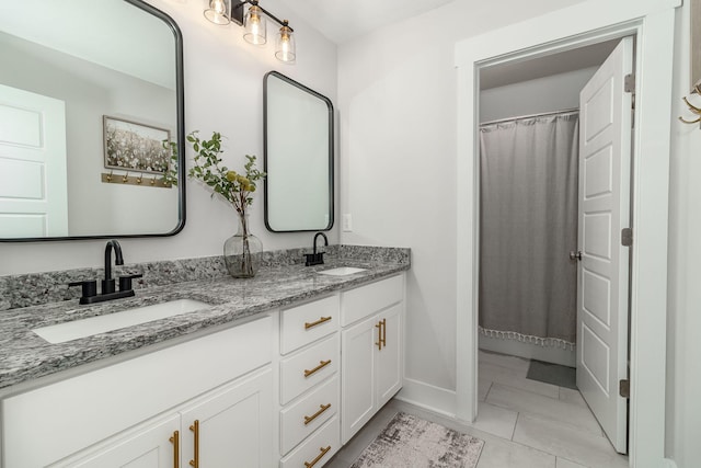 full bath with tile patterned flooring, a sink, baseboards, and double vanity