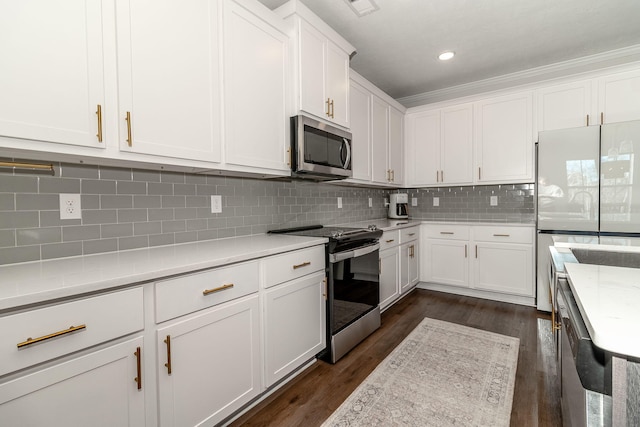 kitchen featuring dark wood-style floors, stainless steel appliances, recessed lighting, decorative backsplash, and white cabinets