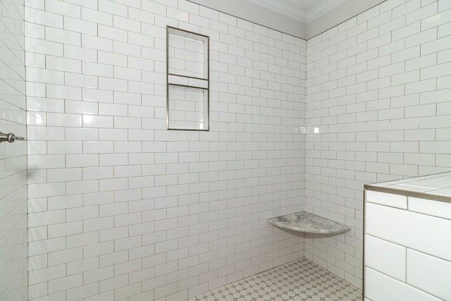 bathroom with ornamental molding and a tile shower