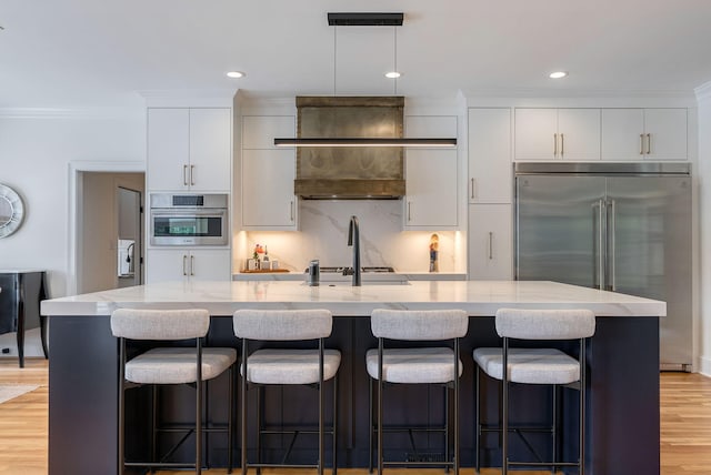 3489 Evans To Locks Rd, Martinez, GA 30907 - kitchen with stainless steel appliances, crown molding, white cabinetry, light wood-style flooring, and an island with sink