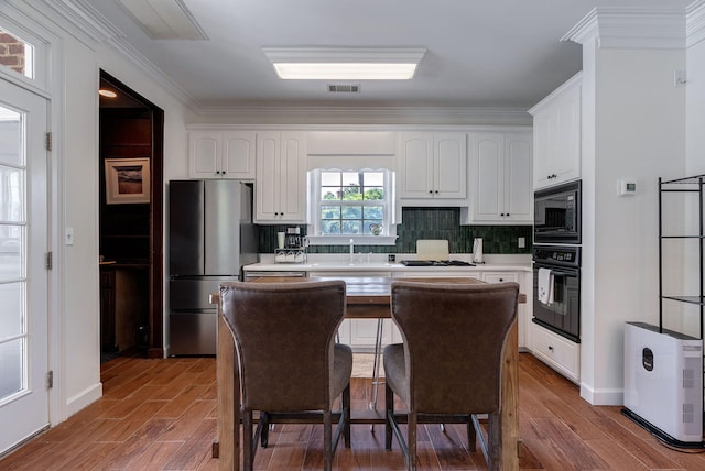 3489 Evans To Locks Rd, Martinez, GA 30907 - kitchen featuring black appliances, wood finished floors, white cabinetry, light countertops, and ornamental molding