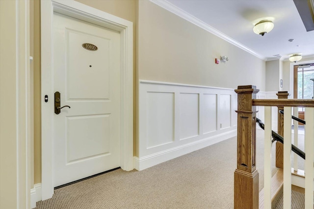 corridor featuring crown molding and light colored carpet