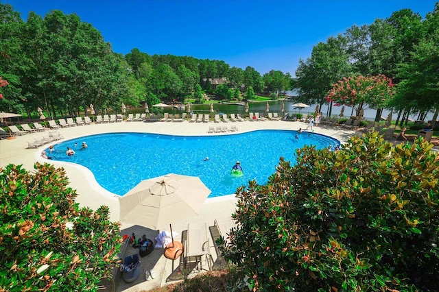 view of pool with a water view and a patio