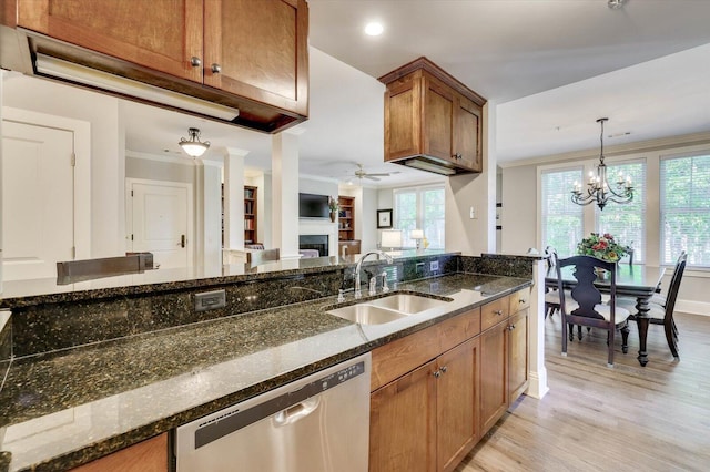 kitchen featuring stainless steel dishwasher, ceiling fan with notable chandelier, sink, and dark stone counters