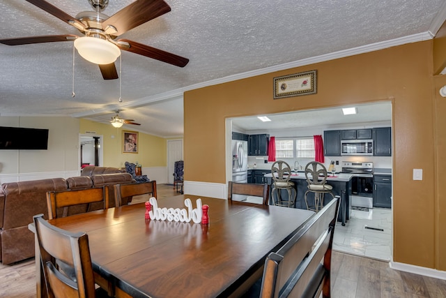 dining room with hardwood / wood-style floors, crown molding, and a textured ceiling