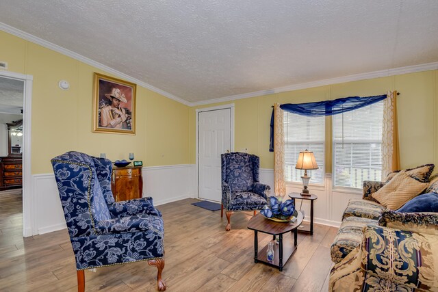 living room with a textured ceiling, hardwood / wood-style flooring, and crown molding