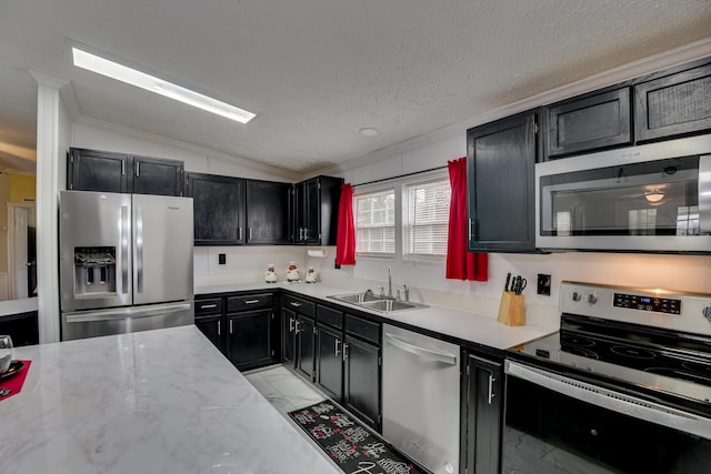 kitchen featuring a textured ceiling, sink, vaulted ceiling, and appliances with stainless steel finishes