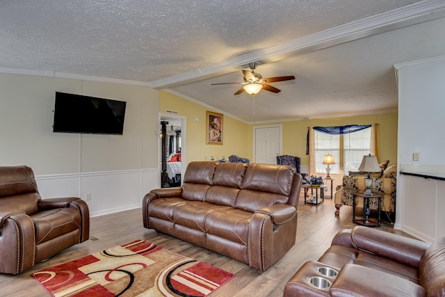 living room with crown molding, ceiling fan, vaulted ceiling, and light wood-type flooring